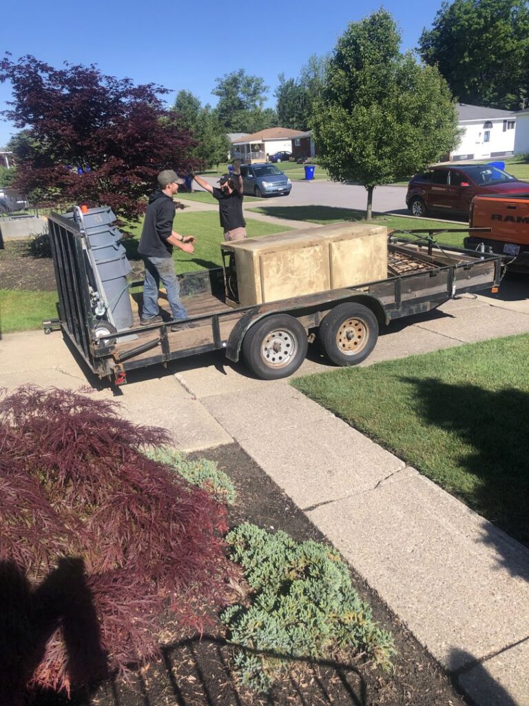 Frankie's Removal Services & Dumpster Rental team loading old furniture onto a trailer for junk removal in Buffalo, NY