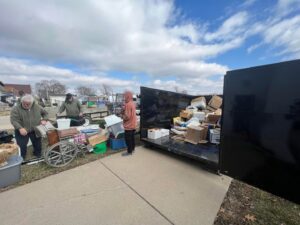 Buzz Dumpster & Junk Removal team loading various items into a dumpster during a junk removal job in Troy, MO.