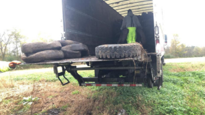 A team member loading old tires onto a truck for Environmental Rubber Recycling in Flint, MI, demonstrating junk removal.