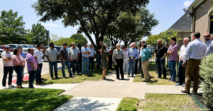 A large team meeting outdoors, representing project coordination by SEDALCO Construction Services in Fort Worth, TX.