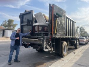 A Tidy Toss Las Vegas, NV team member giving a thumbs up next to a loaded junk removal truck.