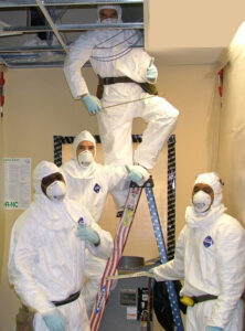 A team of workers in protective suits performing environmental remediation or inspection for Indoor Environmental Systems in Cary, NC.