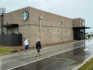 A team pressure washing the brick and stucco exterior of a Starbucks building for Selk Solutions in Crossville, TN.