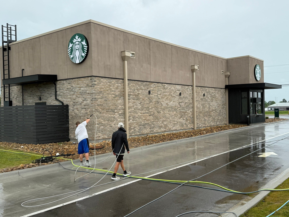 A team pressure washing the brick and stucco exterior of a Starbucks building for Selk Solutions in Crossville, TN.