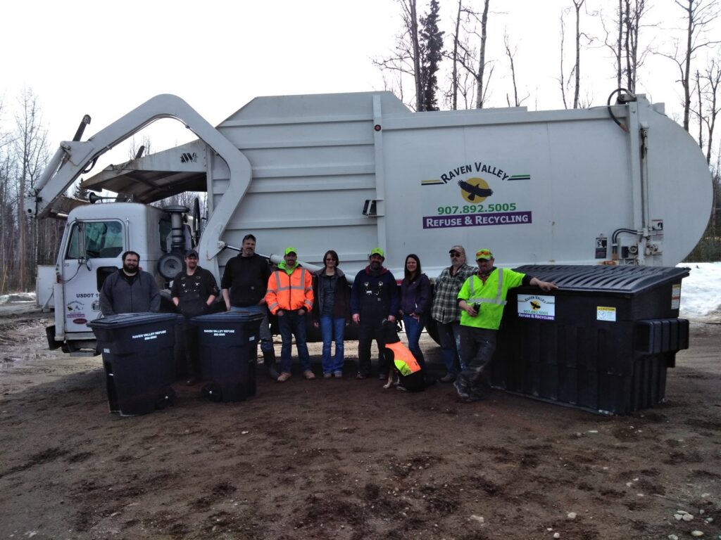 The Raven Valley Refuse and Recycling team standing with their garbage truck and bins in Wasilla, AK.