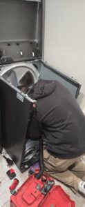 A technician from Appliance Handyman of Twin Falls, ID, working on the internal components of a dryer