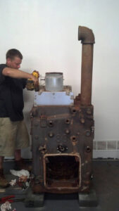A technician from Fletchers Plumbing and Heating repairing an old boiler unit in Smyrna, DE