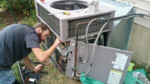 A technician from Cool Change Heating & Air repairing an outdoor HVAC unit in Raleigh, NC.