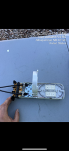 A technician's hand working on fiber optic equipment, showcasing precision work by KPL Fiber Solutions LLC in Houston, TX.