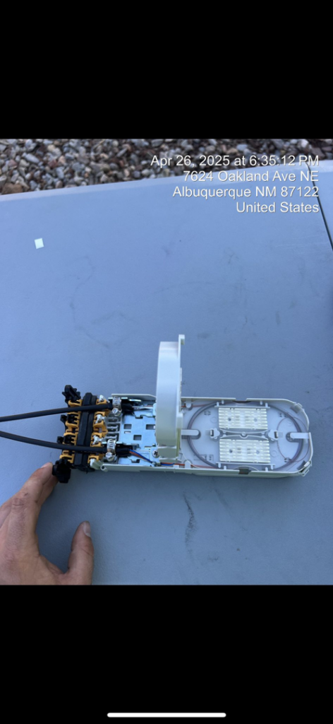 A technician's hand working on fiber optic equipment, showcasing precision work by KPL Fiber Solutions LLC in Houston, TX.