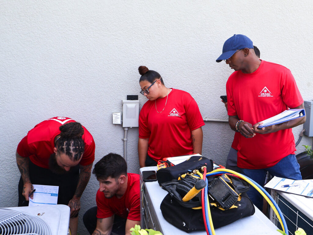Our Place Air & Home Repair technicians inspecting an outdoor HVAC unit in Orlando, FL.