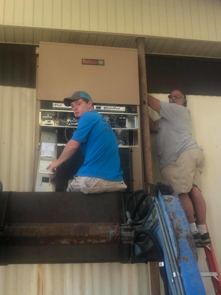 Two technicians installing an HVAC unit for Frankie's Air-Conditioning in Alexandria, LA.