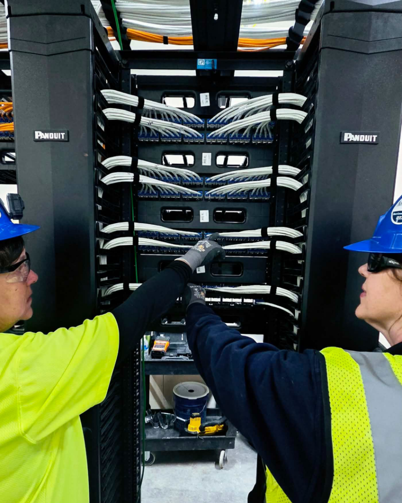 Two technicians working on network cabling in a server rack for OESCO - Oklahoma Electrical Supply Co & Infosys in Oklahoma City, OK