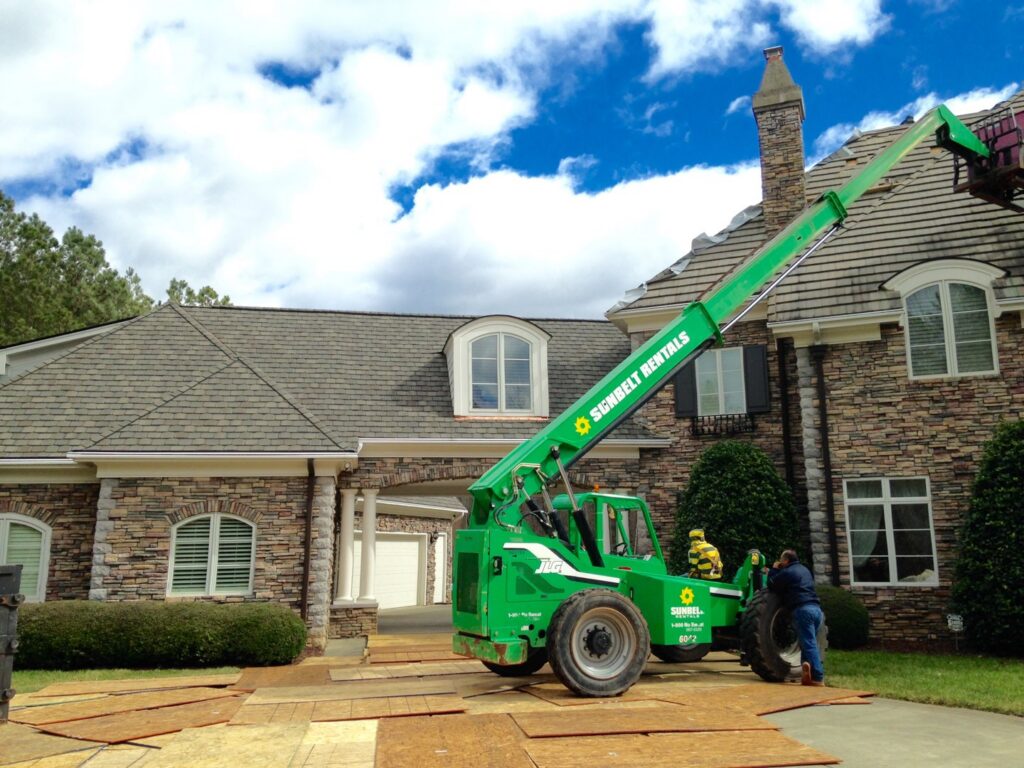 A telehandler lift assisting with a roofing project, a handyman service by Consolidated Roofing Systems, Inc. in Cary, NC
