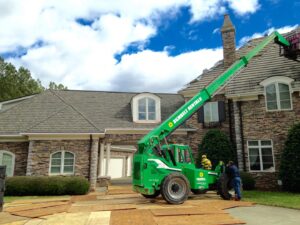 A telehandler lift assisting with a roofing project, a handyman service by Consolidated Roofing Systems, Inc. in Cary, NC