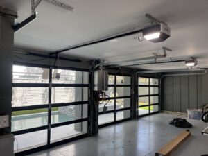 Three glass garage doors with openers installed in a garage by Total Garage Works in Indian Trail, NC.