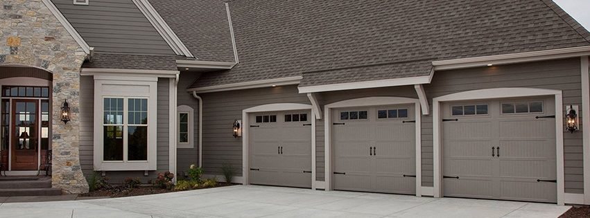 Three modern garage doors installed on a residential house by Big Red Overhead Door, LLC in Moore, OK.