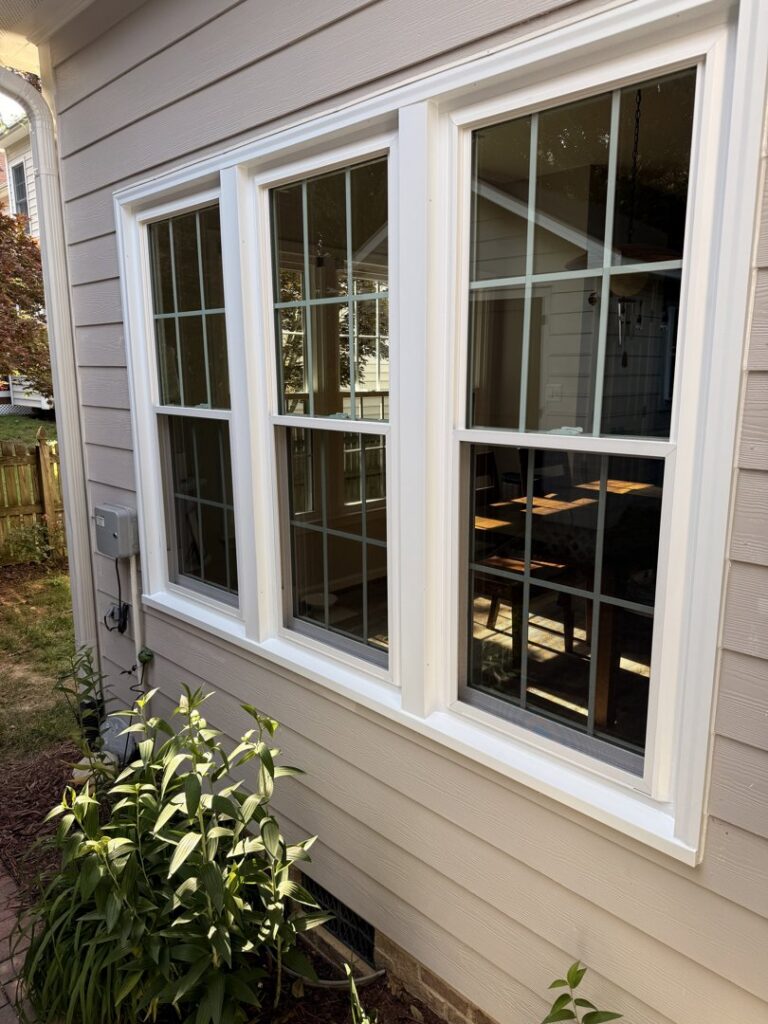 Three newly installed white-framed windows on light-colored siding by NC Siding and Windows in Raleigh, NC