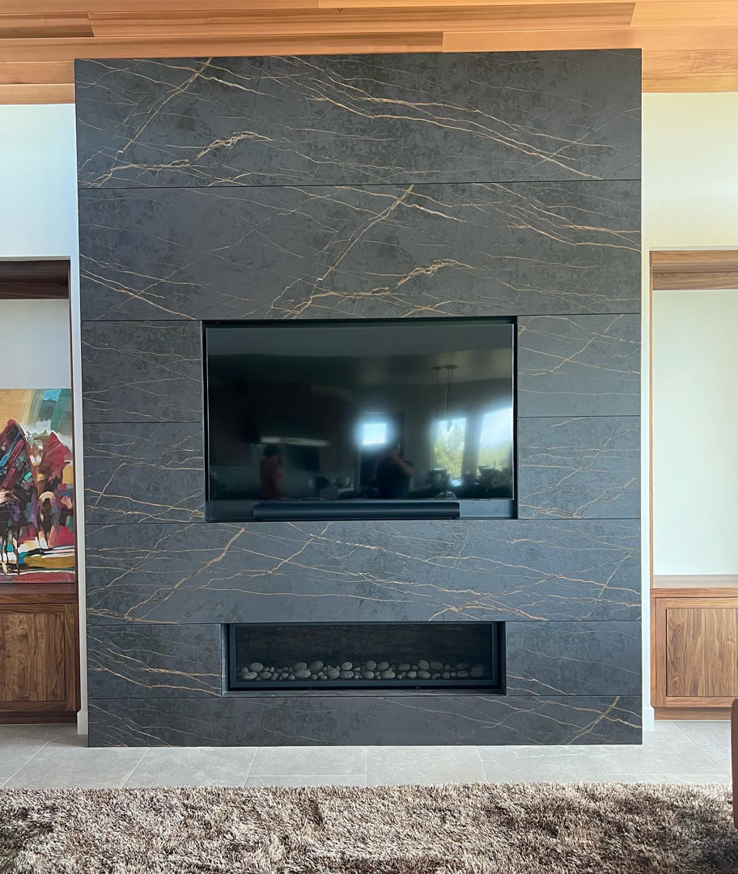 A modern tiled fireplace feature wall with integrated TV installed by Nelson Tile and Stone in Bend, OR.
