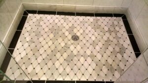 A close-up of a beautifully tiled shower floor with a decorative pattern by Unique Construction Services in Knoxville, TN