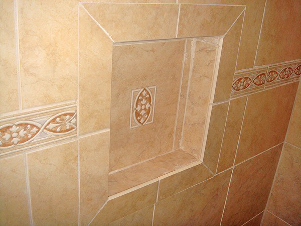 A beautifully tiled shower niche with decorative accents, expertly installed by Tim Moss & Sons Home Improvement in Greensboro, NC.