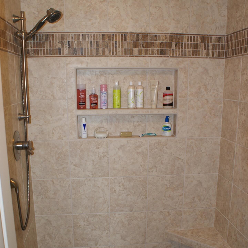 A beautifully tiled shower with convenient built-in niches and a modern shower head by City Home Improvement Inc in Portland, OR.