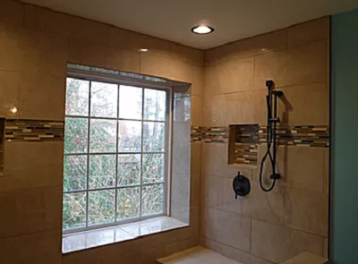 A newly installed tiled walk-in shower with a window, completed by Husbands On Call in Virginia Beach, VA.