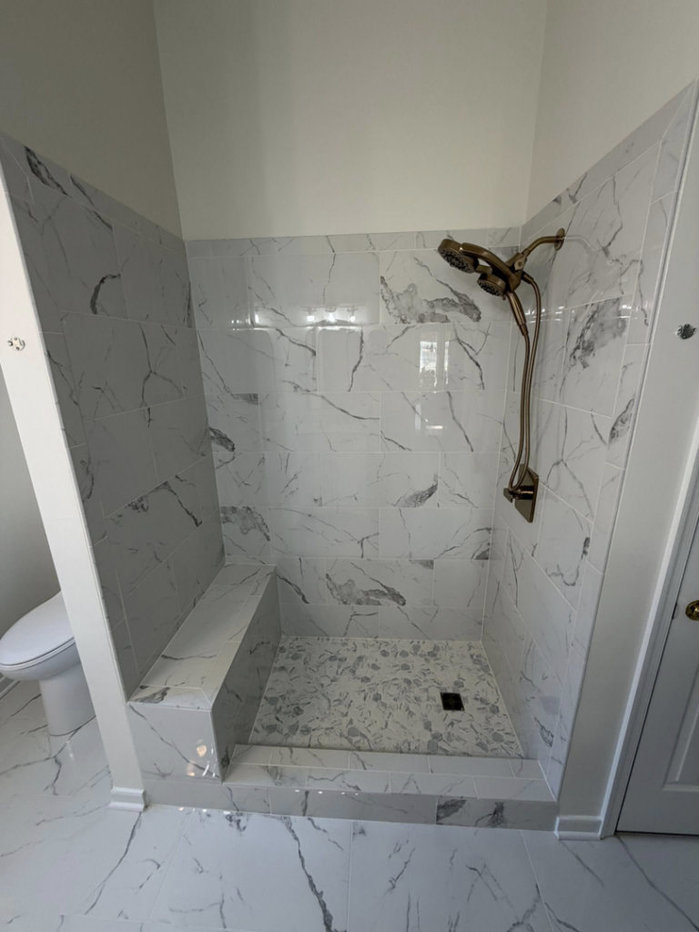 Close-up of a newly installed tiled walk-in shower with a bench by Staley Contracting in Richmond, VA