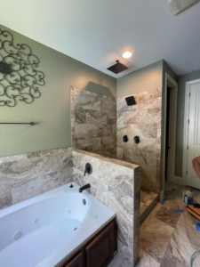 A newly tiled walk-in shower with installed fixtures, ready for glass doors, by RIBAM Residential contractor.llc in Auburn, AL.
