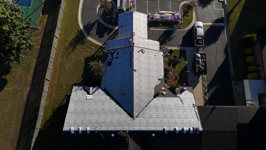 A top-down aerial view of a commercial roofing project in progress by First Choice Roofing in Cary, NC.