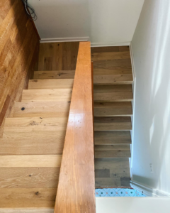 A top-down view of a newly installed wooden staircase and flooring by Savala's Remodeling Services in Austin, TX.