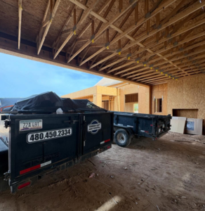 Tough Guy Junk Removal trailers parked at a construction site in Fountain Hills, AZ, ready for debris removal.