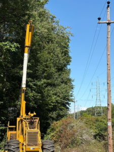 Specialized tracked tree service equipment positioned near trees and power lines by Malec Tree Service in Harrisville, RI