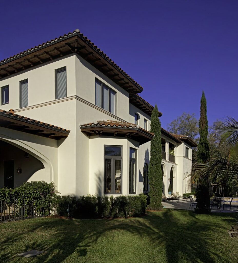 The elegant exterior of a traditional-style home with stucco walls and a tiled roof by Madison Construction Group, Inc. in Miami, FL