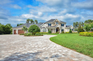A grand traditional luxury home exterior with a large paved driveway and manicured lawn by TamLin Homes Inc in Tampa, FL