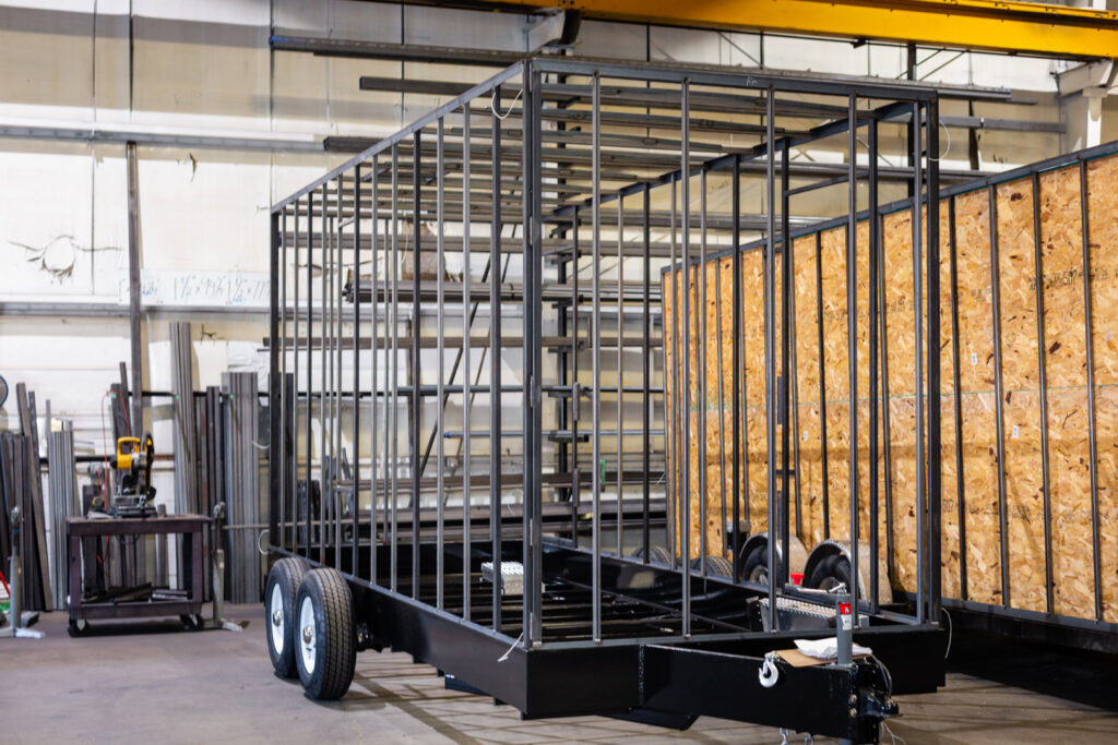 A metal trailer frame under construction in a workshop, showcasing general contractor work by Comforts of Home Services Inc in Aurora, IL