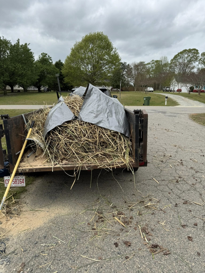 A trailer loaded with hay or straw and yard debris, ready for hauling by JR's Rapid Junk Removal in Cary, NC