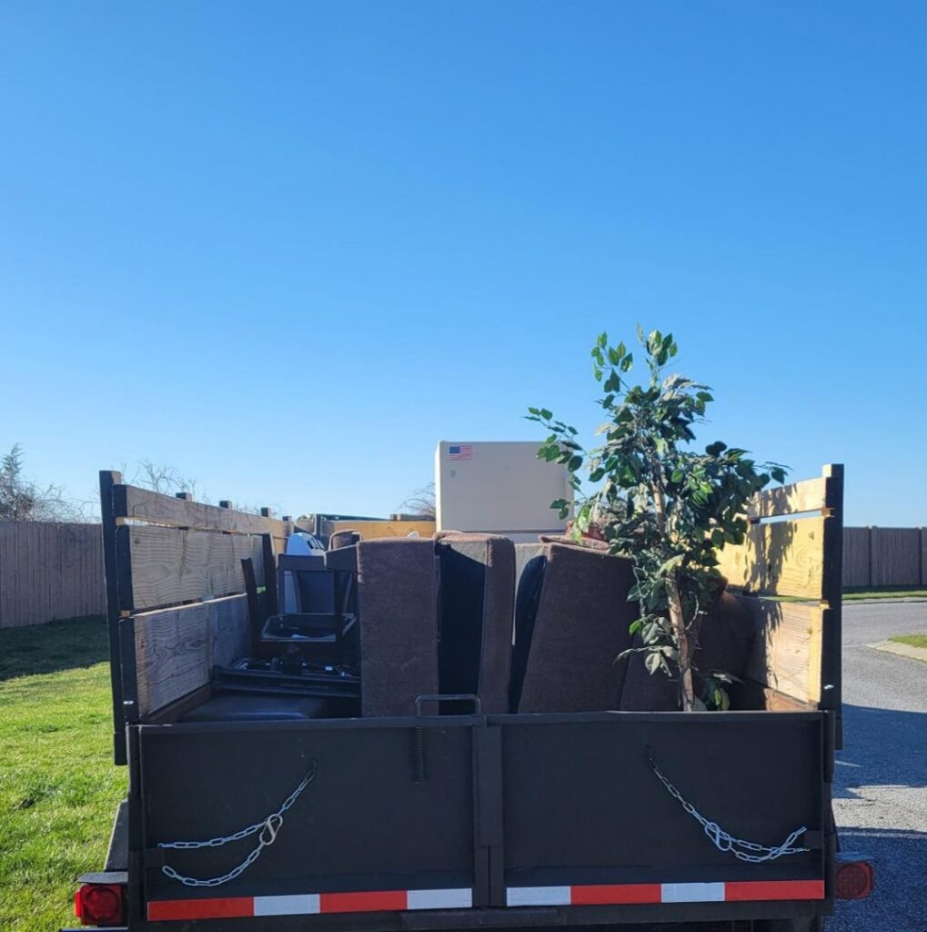 A junk removal trailer filled with furniture and a white appliance by Junk Runner, LLC in East Berlin, PA.