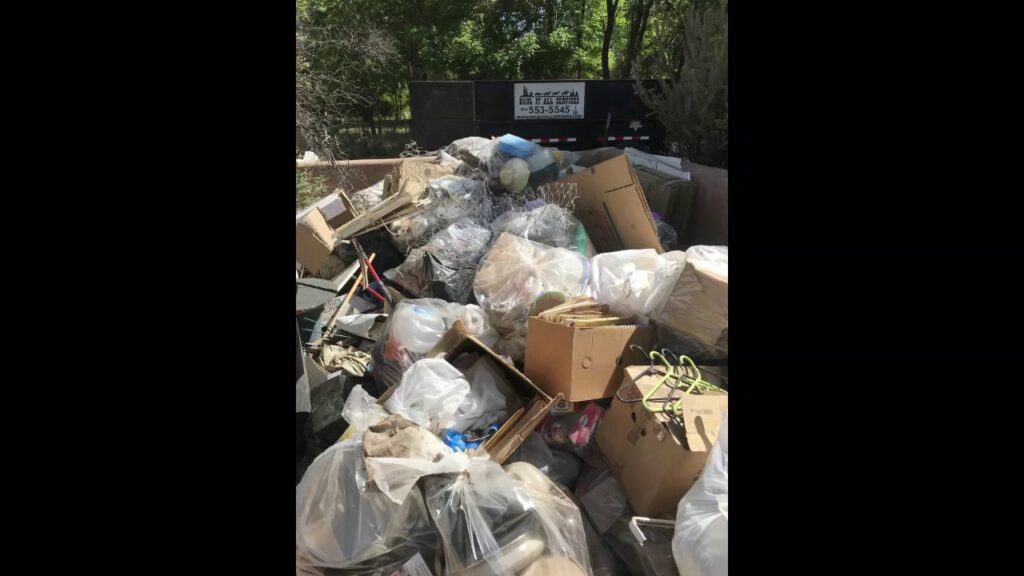 A Haul It All Services trailer completely full of various household junk and debris in Albuquerque, NM