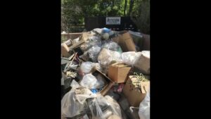 A Haul It All Services trailer completely full of various household junk and debris in Albuquerque, NM