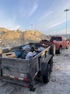 A trailer full of black trash bags and various junk items being hauled by Haul-Away in Anchorage, AK.