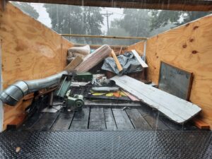 A trailer loaded with various junk items including a mattress, wood, and metal, being removed by Sunshine junk removal LLC in Lake City, MN.