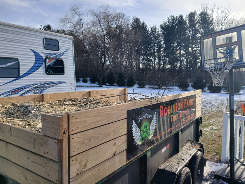 A utility trailer filled with wood chips and tree branches from a job site by RJ Robinson Family Tree Service LLC in York, PA