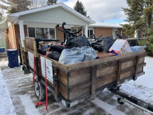 A trailer loaded with black trash bags and other items, showcasing a junk removal job by Feelin Good Junk Removal & Estate Sales at 1111 Debra Lane.