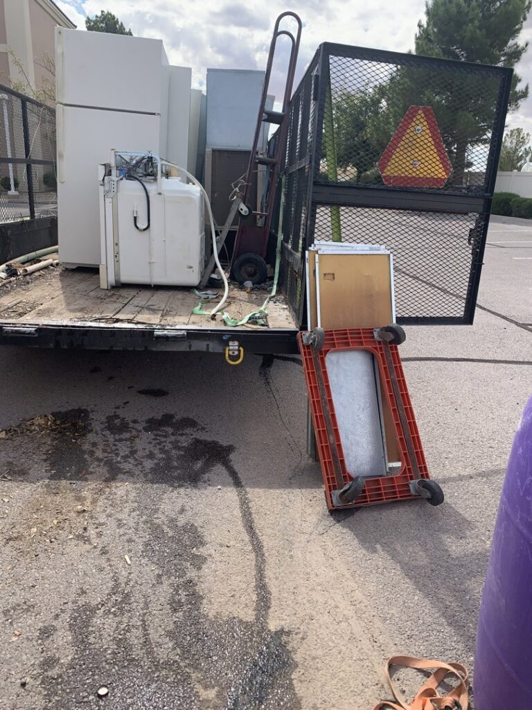 A trailer loaded with several large appliances, including refrigerators and a washing machine, for removal by Roadrunner JunkSmart Solutions LLC in Las Cruces, NM.