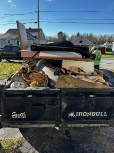 A large trailer loaded high with construction debris, wood, and various junk for removal by O'Brien Property Services in Clay, NY.