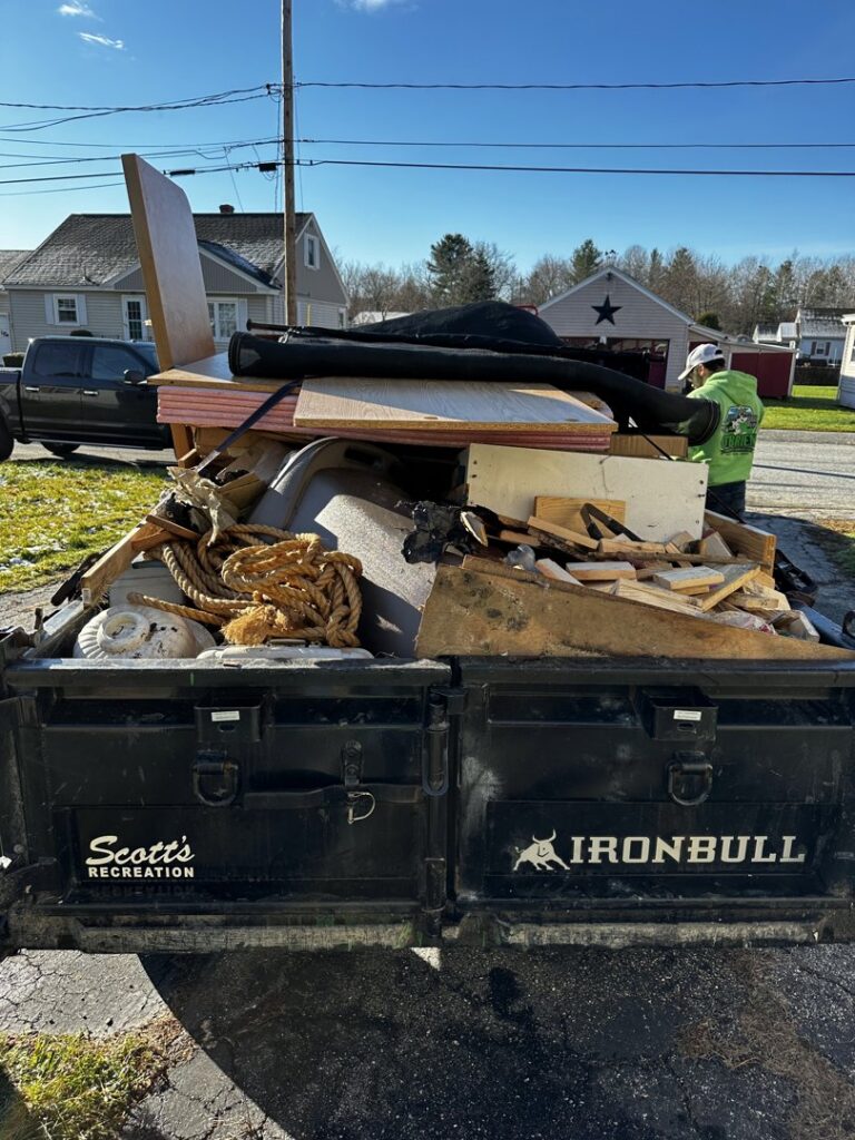 A large trailer loaded high with construction debris, wood, and various junk for removal by O'Brien Property Services in Clay, NY.