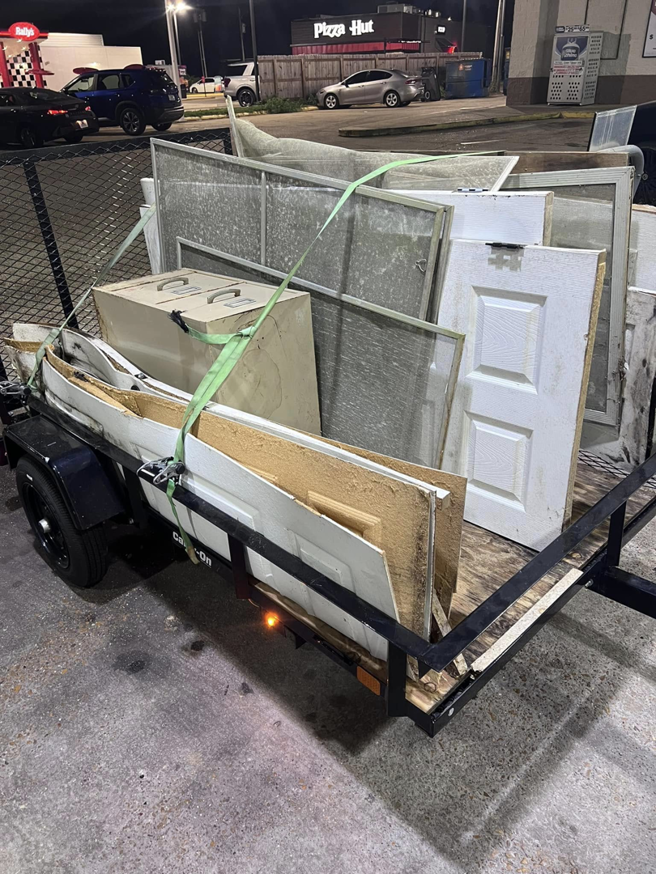 A utility trailer loaded with construction debris for removal by Weekly Waste Solutions in Jackson, MS.