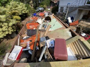 A large trailer loaded with various household debris and junk, ready for transport by EZ Pickups Hawaii LLC in Hilo, HI.