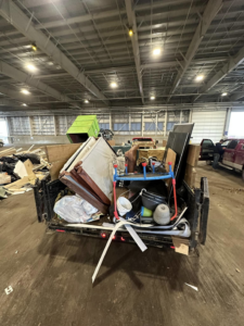 A trailer loaded with household junk, including doors and furniture, ready for removal by Haul-Away in Anchorage, AK.